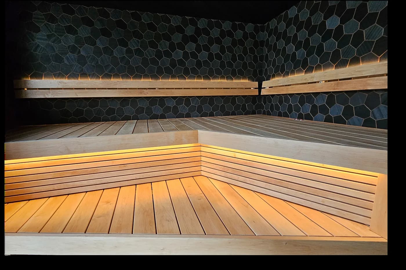 A dark-toned sauna room with DecNord hexa panels